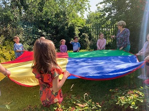 Children holding a large piece of colourful fabric